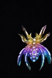 Colorful butterfly-shaped jewelry piece on a black background
