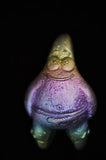 Colorful, abstract object resembling a creature on a black background
