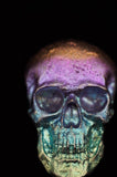 Close-up of a metallic object with intricate designs under a black light.