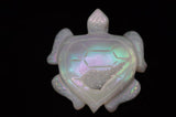 Opalized turtle pendant with iridescent finish on a black background